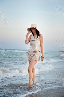 Smiling young woman wearing a straw hat and having fun at the be