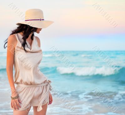 Young beautiful sexy tanned brunette woman wearing straw hat and