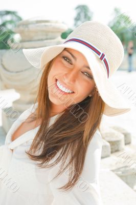 Portrait of pretty cheerful woman wearing white dress and straw 