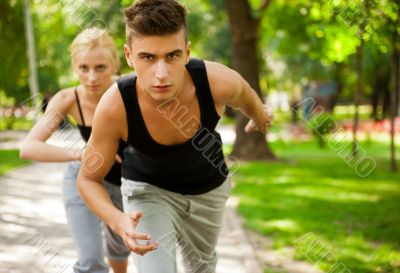 Closeup Portrait of Young Couple Jogging In Park