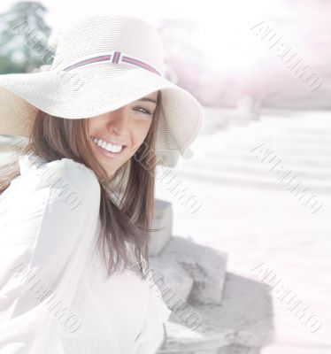 Portrait of pretty cheerful woman wearing white dress and straw 