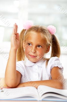 Portrait of a young girl in school at the desk.