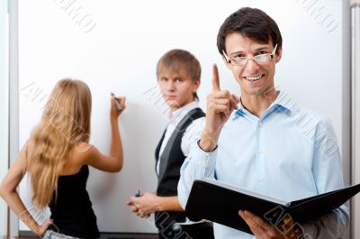 &Ntilde;loseup of adult teacher with student writing on white board at 