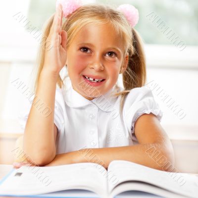 Portrait of a young girl in school at the desk.