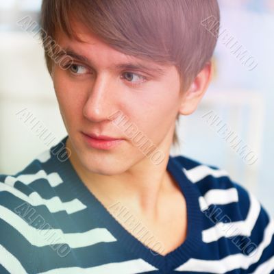 Portrait of young man inside shopping mall sitting relaxed on co