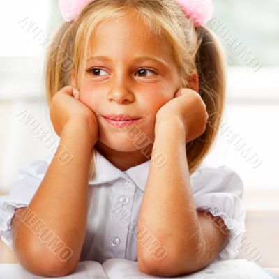 Image of smart child reading interesting book in classroom