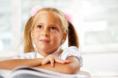 Portrait of a young girl in school at the desk.