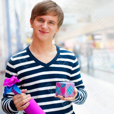 Portrait of young man inside shopping mall standing relaxed and 