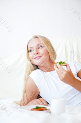 Woman having breakfast in bed. Healthy continental breakfast. Ca