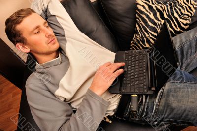 Happy young man  sitting on sofa at home