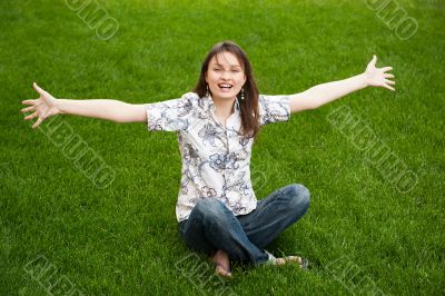 Full length of pretty young woman resting on grass and smiling