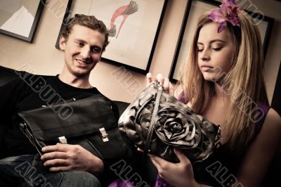 Smiling fashionable rich attractive couple sitting on sofa at ho