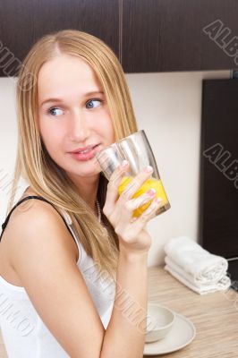 Portrait of beautiful relaxed young woman standing at the kitche