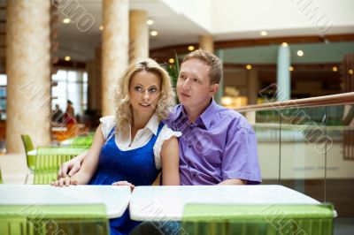 Portrait of a happy young couple looking away while sitting near