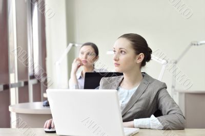 Portrait of two businesswomen listening attentively.