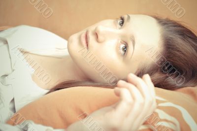 Closeup portrait of young pretty girl laying on her bed