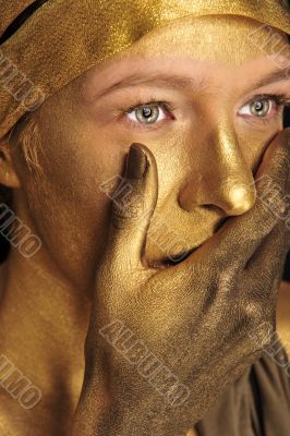 Portrait of young sexy woman in golden paint 