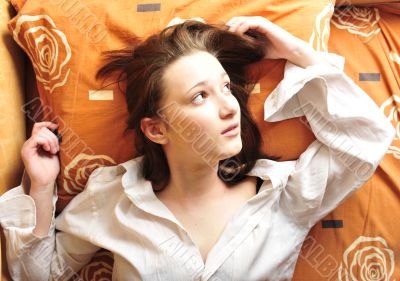 Closeup portrait of young pretty girl laying on her bed