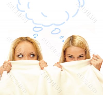 Two women whispering and amazing under blanket