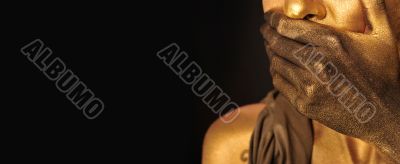 Portrait of young sexy woman in golden paint 