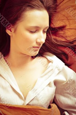 Closeup portrait of young pretty girl laying on her bed