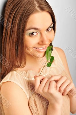 Portrait of young pretty woman holding green leave