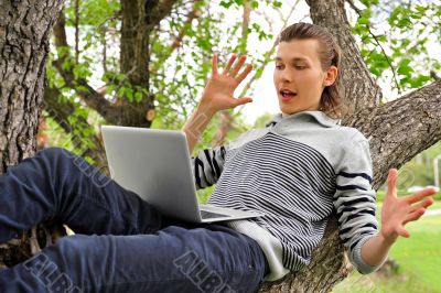 A smiling man with laptop outdoor