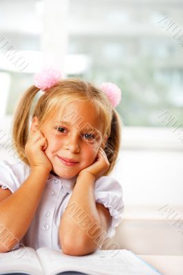Image of smart child reading interesting book in classroom