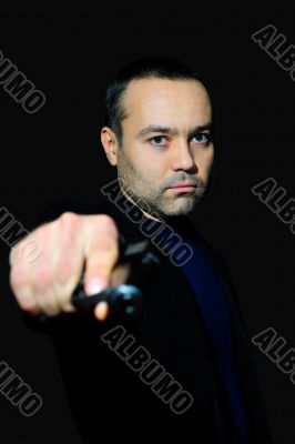 Portrait of a mature man drawing a gun in self defense studio sh