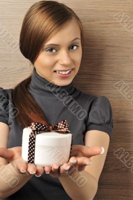 Portrait of a beautiful young woman offering a present.