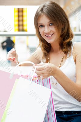 Happy shopping woman with bags and smiling. She is shopping insi