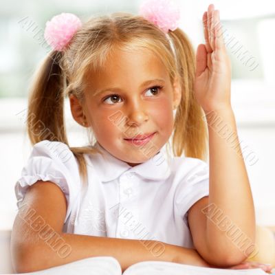 Portrait of a young girl in school at the desk.