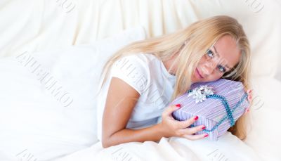 Bedroom surprise present - young happy woman in bedroom