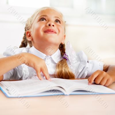 Portrait of a young girl in school at the desk.