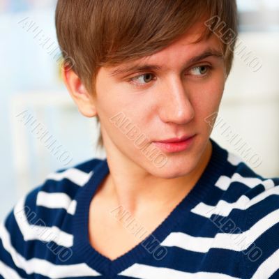 Portrait of young man inside shopping mall sitting relaxed on co