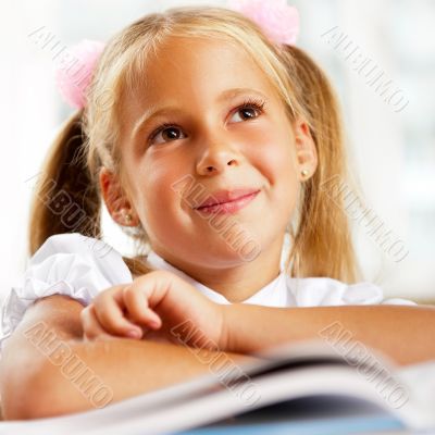 Portrait of a young girl in school at the desk.