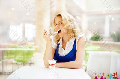 Young woman enjoying coffee time at mall cafe. Eating ice cream 