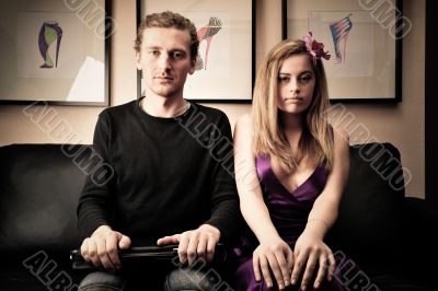 Smiling fashionable rich attractive couple sitting on sofa at ho