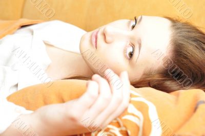 Closeup portrait of young pretty girl laying on her bed