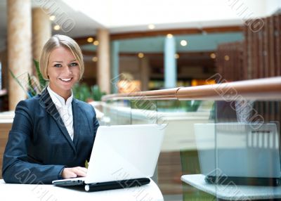Portrait of a pretty businesswoman sitting at cafe with a laptop