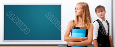 Two students - girl and boy making presentation at classroom