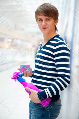 Portrait of young man inside shopping mall standing relaxed and 