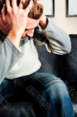 Closeup portrait of young man sitting on sofa 