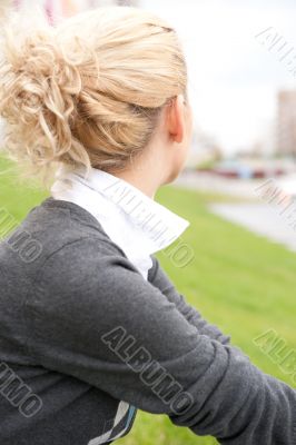 Cute young female sitting on grass and looking away - Outdoor in