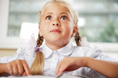 Portrait of a young girl in school at the desk.