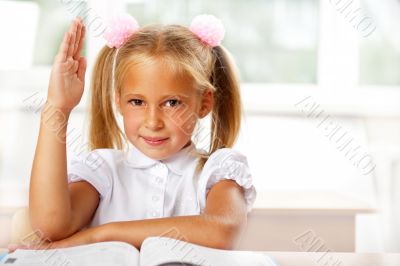 Portrait of a young girl in school at the desk.