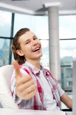 Happy satisfied young man sitting relaxed on his armchair and th