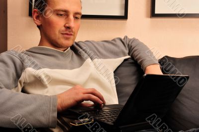 Happy young man  sitting on sofa at home