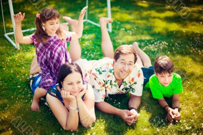 Artistic lifestyle photo of full happy family laying relaxed on 