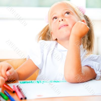 Little girl looking for a drawing concept wile painting picture 